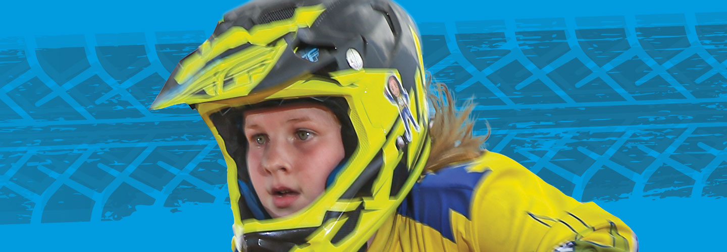 Camdyn riding her bike with a helmet and a focused look on her face