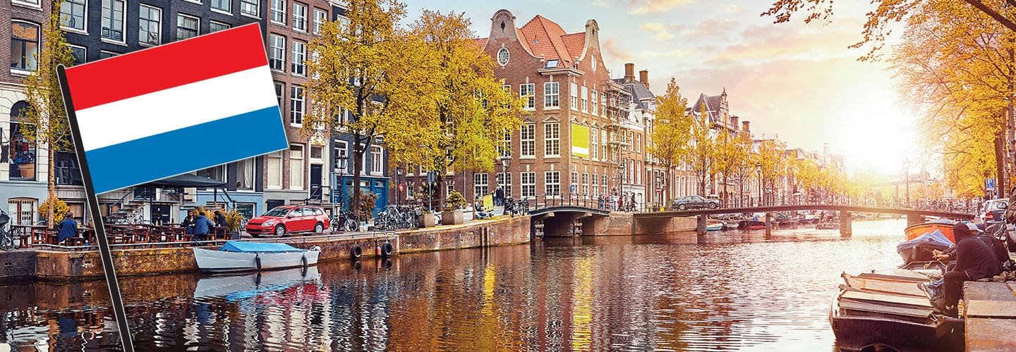 Flag of Netherlands and a sunny canal in the background